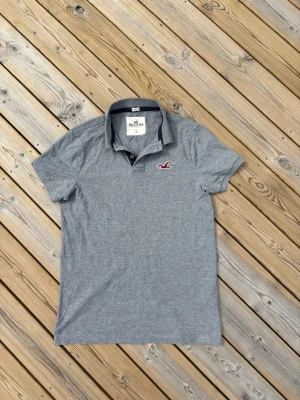 Hollister piké - Säljer denna Hollister piké i mycket bra skick. Storlek M. Passar perfekt för dig som är mellan 177-182! Hör av er vid frågor eller minsta fundering 🙌  Längd: 73,5 cm  Bred: 49 cm  Ärm: 19 cm