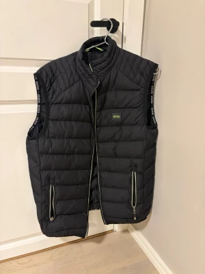 Svart väst från BOSS - Snygg boss väst. Dragkedjans löpare är sönder (se bild 3), därav priset. 