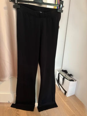 Svarta utsvängda leggings - Säljer ett par svarta leggings med utsvängda ben och slits vid benslutet. De har en hög midja och är gjorda i ett stretchigt, mjukt material som sitter skönt på kroppen. Perfekta för dig som gillar en trendig och bekväm stil.