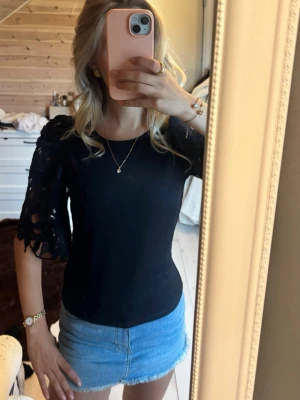 Svart topp med spetsärmar - Snygg svart topp med unika spetsärmar. 