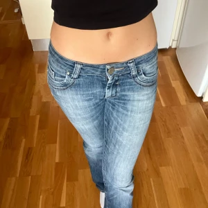 Lågmidjade blå bootcutjeans - Säljer ett par så snygga lågmidjade jeans från märket Cross med snygga detaljer.               Storlek W26 L34. Är mina älsklingsjeans men de är tyvärr för långa, därav säljer jag dem 💗