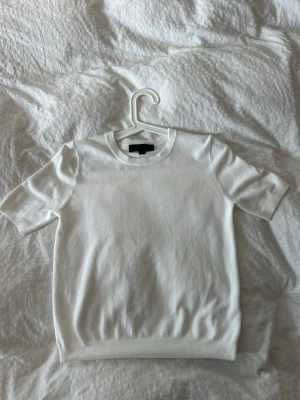 Vit  topp med kort ärm - Snygg vit stickad topp med rund halsringning och korta ärmar. Toppen är från Zara och är knappast använd.
