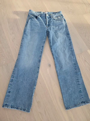 Blå raka jeans från Gina Tricot - Säljer ett par klassiska blå jeans från Gina Tricot i rak modell. Jeansen har fem fickor, normal midja och är gjorda i slitstarkt denimtyg. Aldrig använda. 