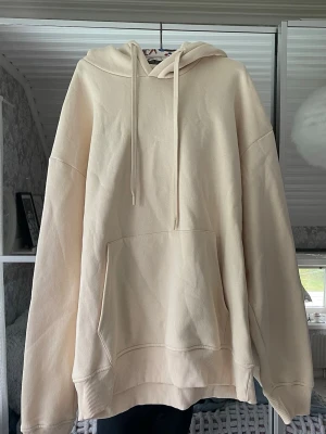 Beige hoodie  - Säljer en beige hoodie med stor känguruficka framtill och dragsko i huvan. Hoodien har ribbade muddar vid ärmslut och nederkant. Från herravdelningen, storlek M. Aldrig använd, mjuk insida. 
