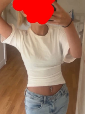 Vit crop top med knytning i ryggen - Säljer en vit crop top med korta ärmar och snygg knytning i ryggen. Toppen är figurnära och har en enkel, stilren design som passar perfekt till jeans eller kjol. Materialet känns mjukt och bekvämt mot huden.