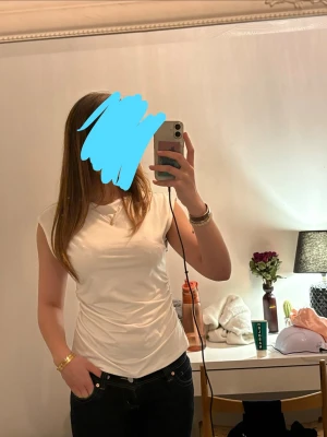 Vit offshoulder topp - Säljer en topp med en lite glansig finish. Toppen har en figurnära passform och korta ärmar, perfekt för en stilren och enkel look. Har används 1 gång💘