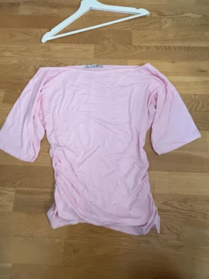 Ljusrosa topp från 157 - Säljer en ljusrosa topp från 157 med trekvartsärm och enkel, clean design. Toppen är tight i midjan och har en relaxed passform överallt annars som passar perfekt till jeans eller kjol. 