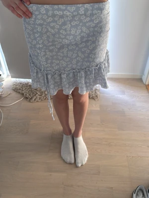 Kjol - Fin kjol med vita blommor på. Aldrig använd och i nytt skick