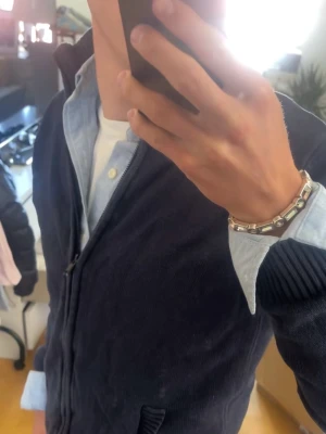 Sällsynt Fullzip - Snygg mörkblå tröja med dragkedja framtill och ståkrage. Tröjan har ribbade muddar vid ärmslut och nederkant, samt fickor på sidorna. Perfekt för dig som gillar en stilren och avslappnad look.