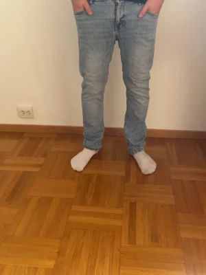 Ljusblå raka jeans herr - Säljer ett par ljusblå jeans med rak passform och klassisk femficksdesign. Jeansen har normal midja och är tillverkade i denim med lätt tvättad look. Perfekta för en avslappnad och stilren outfit.