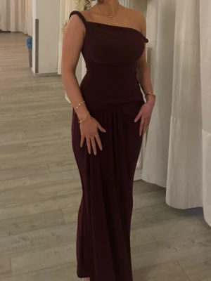 Vinröd oneshoulder långklänning - Säljer en elegant vinröd långklänning med oneshoulder-design och figurnära passform. Endast använd dn gång! Ny pris 1600💕