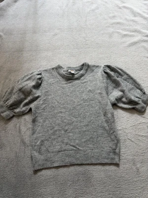 Grå stickad tröja från Gina Tricot -  jag säljer en ljusgrå stickad tröja från Gina Tricot