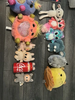 Samling gosedjur och mjukisdjur uppe kostar 45kr nere kostar 100 alla kostar 500nere kostar 150kr allt kostar 800 - Säljer en samling med olika gosedjur och mjukisdjur i flera färger och former, inklusive fantasidjur, lamm, räv, varg, en Coca-Cola burk i tyg och en rund gul mjukis med öron. Perfekt för dig som gillar söta och unika mjukisdjur att samla eller ge bort.