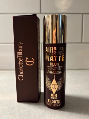 Charlotte Tilbury Airbrush Setting Spray - Airbrush Flawless Setting Spray Matte Blur från Charlotte Tilbury. Kommer i en mörkbrun flaska med gulddetaljer och matchande förpackning. Ger en matt finish och hjälper till att fixera makeupen hela dagen. Innehåller 100 ml.