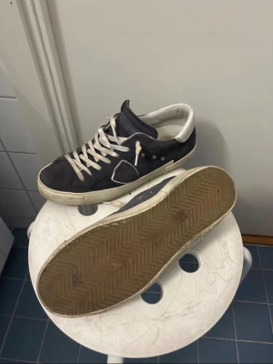 Philippe Model Paris sneaker mocka storlek 41 41 - Säljer ett par Philippe Model Paris sneakers i mörkblå mocka med vita detaljer. Använda men fortfarande i bra skick. Jag skulle passa på att säga dessa skor är lite stora i storlek, själv har jag eu 42,5 och de passar perfekt