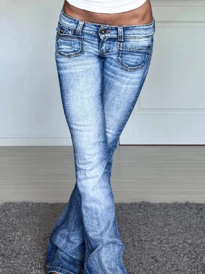 Ljusblå bootcut jeans med slitningar - Säljer ett par ljusblå lågmidjade bootcut jeans midjemåttet är 34cm raktöver och innerbenslängden 76cm