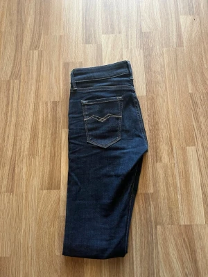  replay  - Säljer ett par mörkblå replay jeans med klassiska kontrastsömmar och två bakfickor med dekorativ. perfekta till vardagslooken.