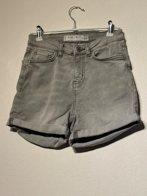 Amisu jeansshorts - Säljer ett par gråa high waist shorts från Amisu. De har klassisk femficksdesign, uppvikta benslut och stängs med knapp och dragkedja. Perfekta till sommaren och lätta att matcha med olika stilar.