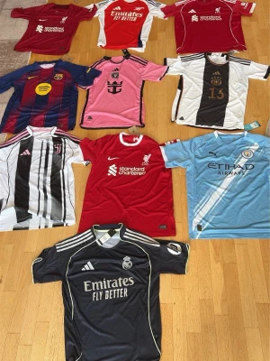 Fotbollströjor från kända klubbar - Säljer flera fotbollströjor från klubbar som FC Barcelona, Juventus, Liverpool, Manchester City och Real Madrid. Tröjorna har olika färger och tryck, med klubbmärken och sponsorloggor. Perfekta för dig som älskar fotboll och vill bära din favoritklubbs färger. Kom dm för diskussion om priset