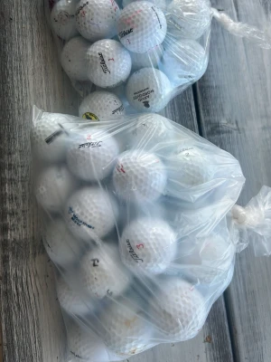 Två påsar med golfbollar - Säljer 52 stycken vita golfbollar med märket Titleist det är lite olika Titleist modeller.
