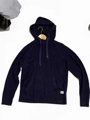 Mörkblå stickad hoodie med ficka - Mörkblå stickad hoodie med luva och dragsko. Klassisk känguruficka framtill och ribbade muddar vid ärmslut och nederkant. Perfekt för dig som gillar en enkel och stilren look.