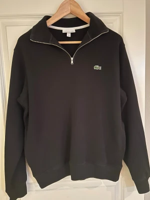 Lacoste half zip tröja – svart – fint skick - Säljer en stilren svart half zip tröja från Lacoste.Tröjan är knappt använd och i mycket fint skick. Säljer den då den tyvärr är för liten för mig.                 Storlek: M                                                                             Nypris 1200kr, säljer för 240 vid meet upp i Stockholm 