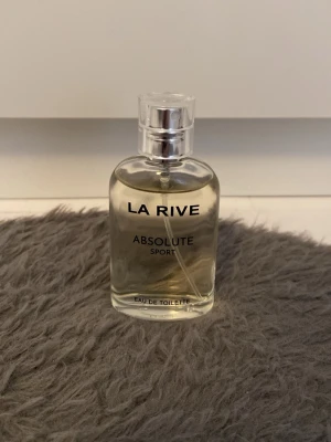 La Rive Absolute Sport parfym - Fräsch parfym från La Rive, Absolute Sport. Kommer i en genomskinlig glasflaska med silverfärgad kork och stilren design. Förpackningen är silverfärgad med tydlig text. Perfekt för dig som gillar sportiga och energiska dofter.