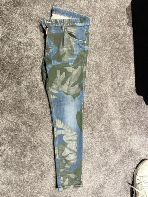Camo-mönstrade dsquared2 jeans - Dsquared2 Jeans, nypris ca 6000kr. Använda två gånger. Storlek 50 motsvarar 34-36.
