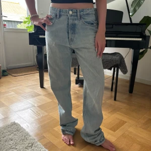 Ljusblåa jeans från zara - Ljusblåa jeans från zara i st 36. Super fin modell, hon på bilden är 160 cm lång och dom går över hennes fötter. Använda ganska mycket men i ett jättefint skick!