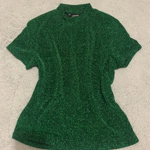 Glittrig monki tshirt - Jag N grön glittrig monki T-shirt som kan användas på nyår eller andra fester💕 Tröjan är knappt använd och priset kan diskuteras💕 Obs köparen står för frakt💕