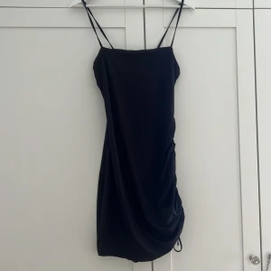 Svart klänning från divided  - Svart klänning från H&M/divided i bra skick med resårknytning på ena sidan. Köparen står för frakt, priset kan diskuteras vid snabb affär. Storleken är true to size (M).