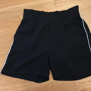 Svarta shorts  - Andvända men fortfarande rätt så bra skick. Det är svart kostym shorts med vita detaljer på sidan. Riktigt snyggt! 