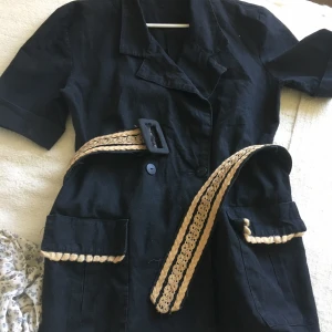 Vintage 90-talet kavaj kort arm - Vintage 90-talet kort arm kavaj  . Bälte följer med  .har två stora djupa fickor .storlek är stor medium eller Lars  passar också . Längd ca 74cm Skriv gärna om ni vill exat mått