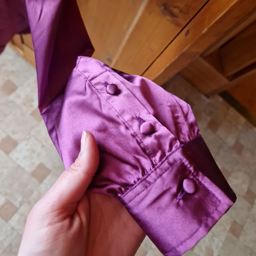 En skjortklänning/tunika i en fin lila färg med knappstängning och knappar i ärmsluten och lite slits i sidorna. Storlek 36/38. Klänningar.