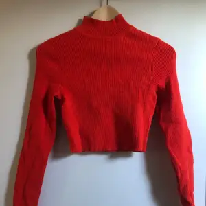 Röd kort tröja med hög krage från HM. Mycket var skick, knappt använd. Stretchiga material.  