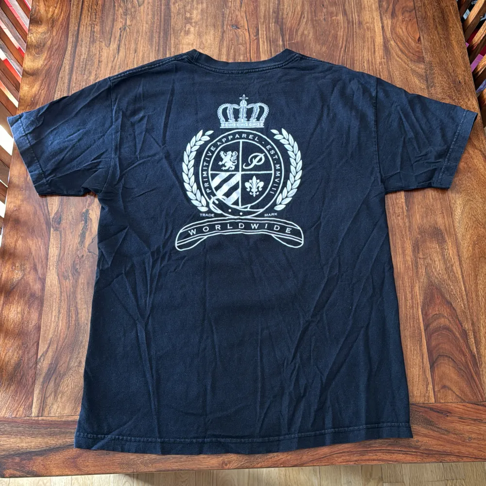 En svart primitive T-shirt med tryck på framsidan och baksidan. En hyfsat använd tröja med mycket kvar att ge. Condition: 6/10. T-shirts.