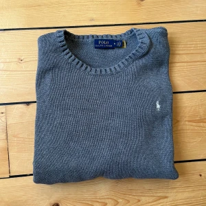 Grå Ralph lauren tröja - Grå Ralph lauren tröja i bra skick. Det står att tröjan är storlek M men passar storlek S/XS. Nypris är ca 2000kr, vårt pris är 449kr.