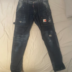 Dsquared2 jeans - Dsquared2 jeans i storlek 48. Jeansen är köpta för runt 4 år sedan för 7699kr.  Kvitto finns. jeansen är i väldigt bra skick då jag inte använt dem så mycket. Det finns inga fläckar eller hål (bortsett från designen) Meddela gärna om du har frågor:)