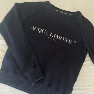 Hoodie - En mörkblå hoodie från acqua limone. Den har en liten fläck på framsidan.