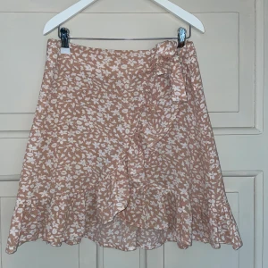 Sommarkjol - Söt rosa sommarkollo med knytning och volanger. Säljer då den är för liten och inte kommmer till användning längre.