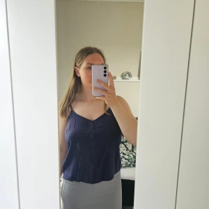 Blått linne - Ett mörkblått linne med smala axelband i mycket bra skick, som passar till allt