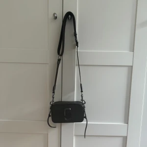 Marc Jacobs ”the snapshot dtm”  - Säljer min fina mörkbruna Marc Jacobs väska. Säljes då den inte kommer till användning! Använt fåtal gånger så nästan helt nyskick! 🥰  Nypris 4599kr  Mått: H 11 x B 18,5 D 6,5 
