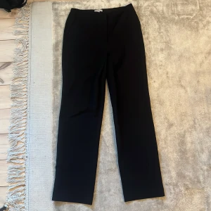 Svarta kostymbyxor  - Midwaist kostymbyxor. Byxorna är i bra skick förutom att det finns en liten klorfläck längst ner på byxan. 