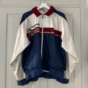 Champion Jacka - En vintage oversized blå, röd och vit Champion jacka men gömd huva i kragen.