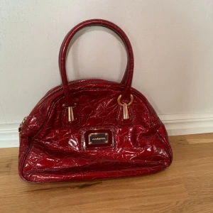 Röd väska  - Höjd 26 cm, bredd 33 cm  Mellanstor väska  Märke robaccorocco Velvet material inuti Säljes på en annan sida också så skriv vid intresse, köparen står för frakt 