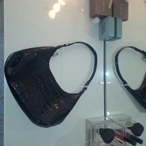 Svart väska 🖤 - Svart glansig väska från gina med "orm-mönster" typ. Super snygg, men har inte kommit till så mycket användning dock, tyvärr. 🤍 