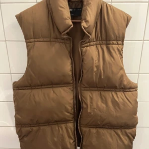 Brun dunväst  - En brun dunväst från asos i storlek L. Säljer den pågrund av att den inte längre passar på mig. Den värmer väldigt mycket och den passar till det mesta! 