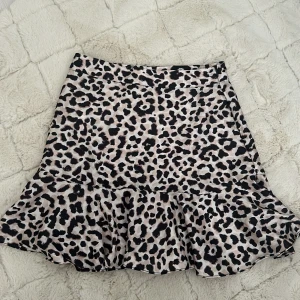 Leopardmönstrad kjol från Amisu - En leopardmönstrad kjol från New Yorker med volangdetaljer. Kjolen har en normal passform och är kort i längden. Använd en gång på grund av att den är tajt på.