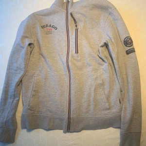 Sebago tröja med dragkedja - Mycket bra skick, Herr storlek M Något sliten i sömmarna vid fickan (se bild), lite missfärgad vid nedre mudden (se bild 1)