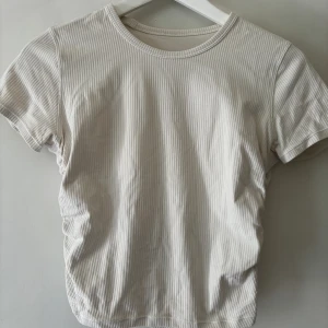 Lululemon T-shirt - Helt oanvänd T-shirt från Lululemon i ribbat material, Strl 4 motsvarar Xs/S
